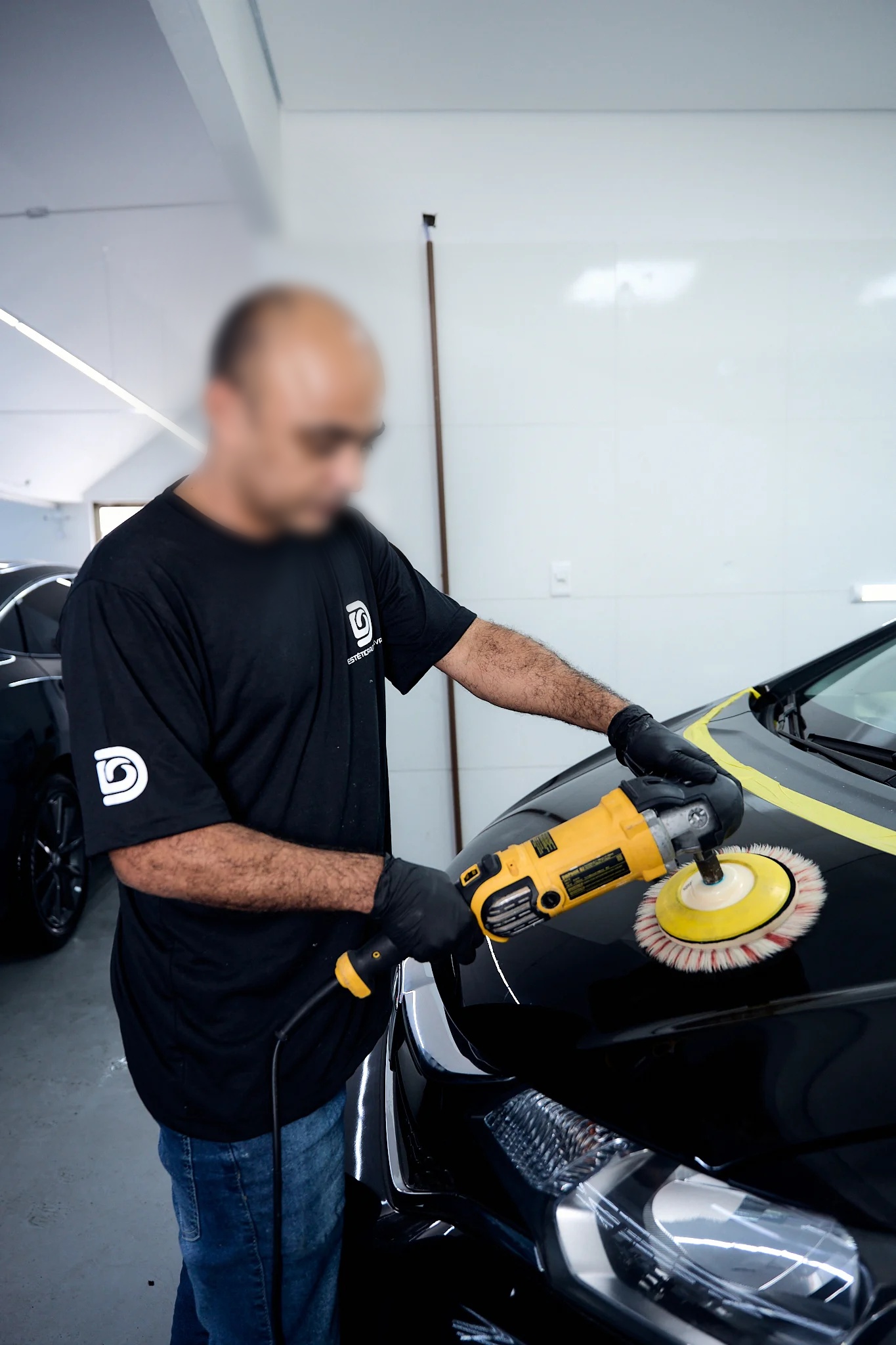 Profissional executando polimento automotivo.
